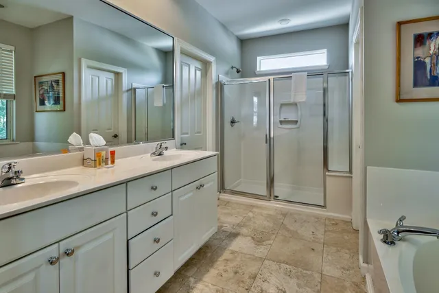 a bathroom with a double vanity sink mirror double and shower