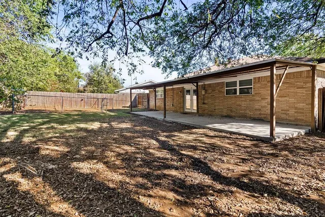 a backyard of a house with yard and outdoor seating