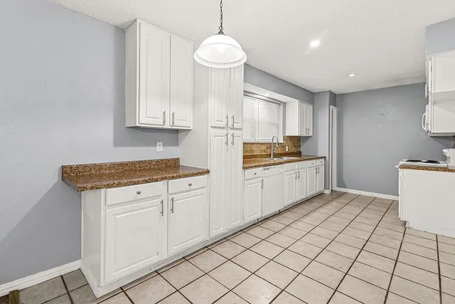 a kitchen with granite countertop white cabinets and white appliances