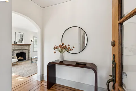 a room with a chair a mirror and a fireplace