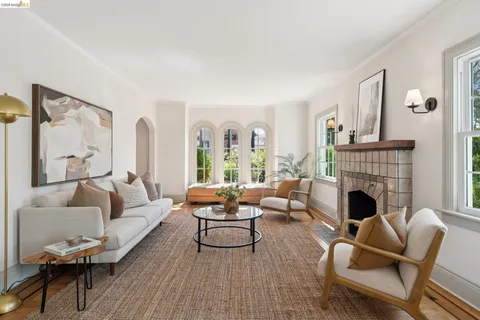 a living room with furniture fireplace and a large window