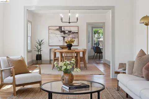 a living room with furniture a chandelier and a dining table
