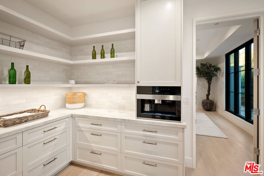 10444 Charing Cross Road Los Angeles, CA 90024 - Photo 17 of 74 a kitchen with white cabinets and black appliances