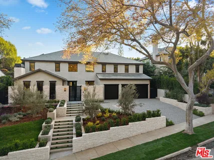 a front view of a house with yard and green space