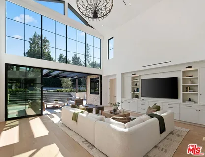 a living room with furniture a flat screen tv and a floor to ceiling window