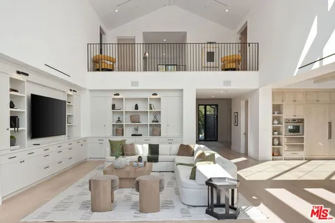 a large kitchen with stainless steel appliances a sink a stove and white cabinets next to a window