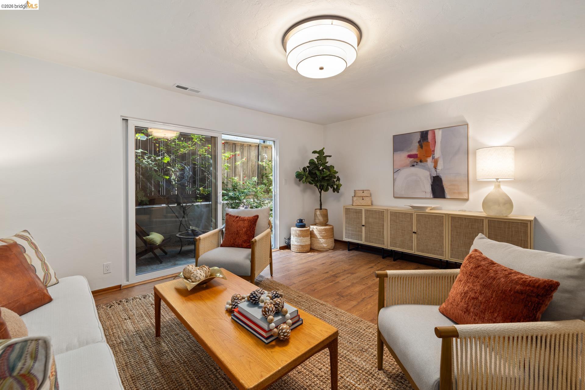 6660 Sobrante Road Oakland, CA 94611 - Photo 17 of 48 Wood-finish flooring, white walls, and a contemporary flush-mount light fixture