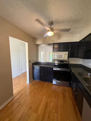 a kitchen with stainless steel appliances granite countertop a refrigerator and a stove