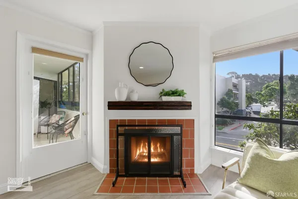 a living room with a fireplace and a floor to ceiling window