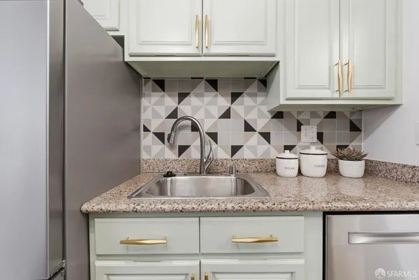 a kitchen with granite countertop a sink and cabinets