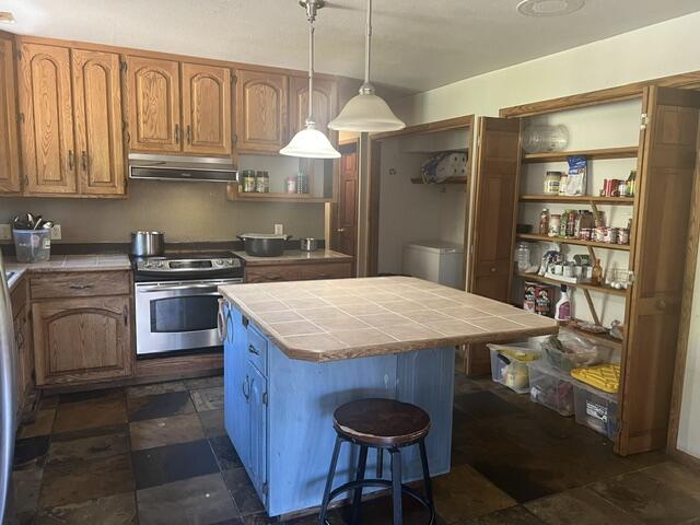 4196 East Evans Creek Road Rogue River, OR 97537 - Photo 14 of 36 a kitchen with stainless steel appliances granite countertop a stove a refrigerator and a wooden cabinets