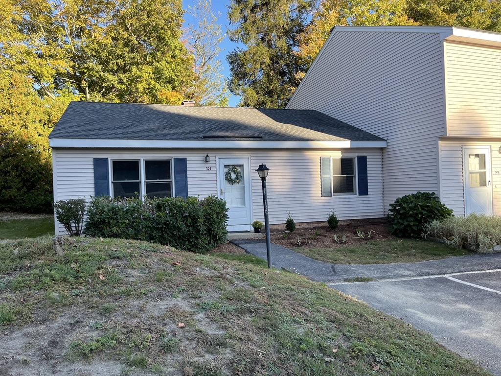 a front view of house with yard and trees around