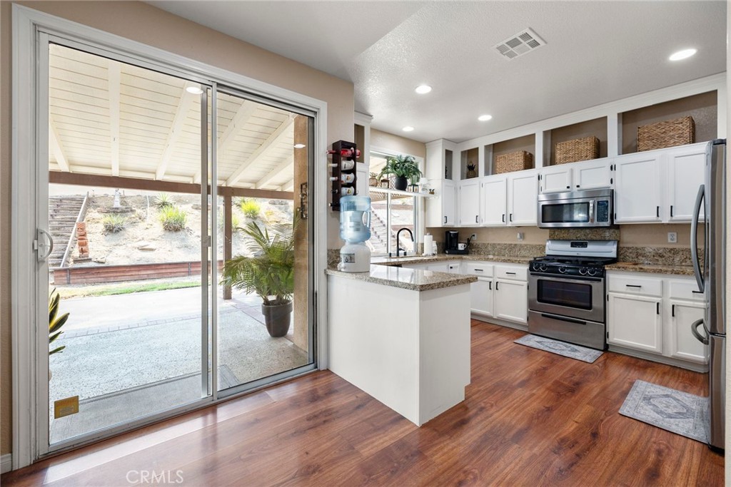17821 Morning Rock Circle Riverside, CA 92503 - Photo 16 of 47 a kitchen with white cabinets and appliances