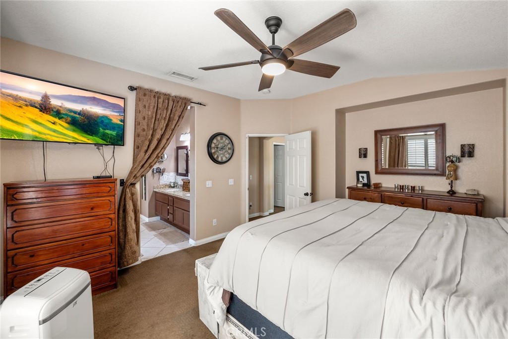 17821 Morning Rock Circle Riverside, CA 92503 - Photo 27 of 47 a bedroom with a bed and a chandelier