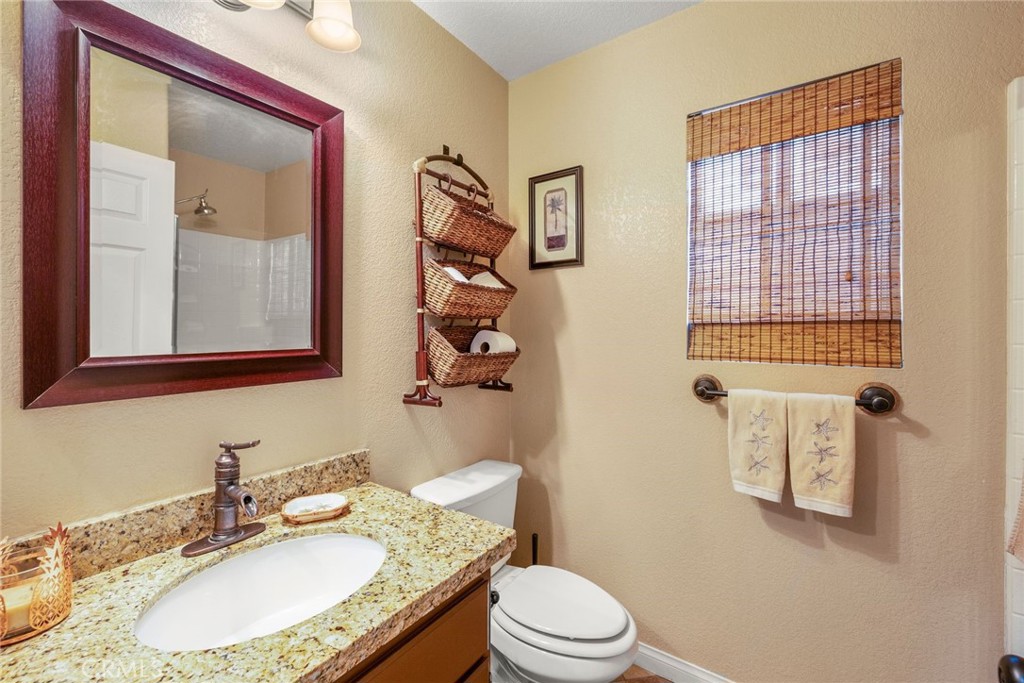 17821 Morning Rock Circle Riverside, CA 92503 - Photo 10 of 47 a bathroom with a granite countertop sink mirror vanity and toilet