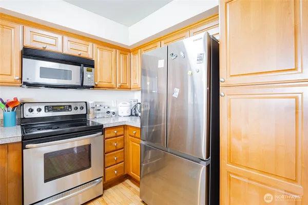a kitchen with stainless steel appliances granite countertop a sink stove and microwave
