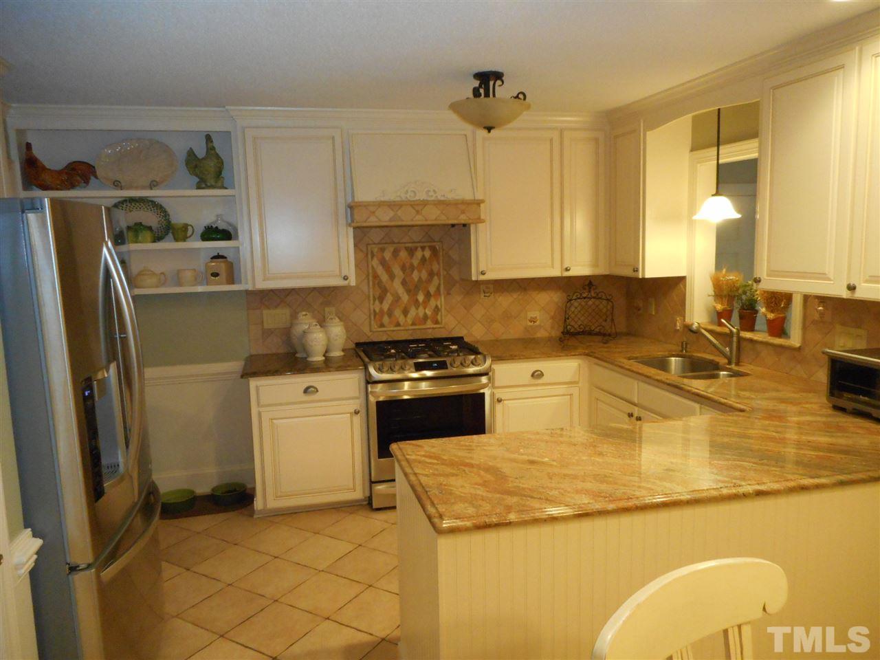 7920 Sutterton Court Raleigh, NC 27615 - Photo 2 of 22 a kitchen with a sink appliances and cabinets