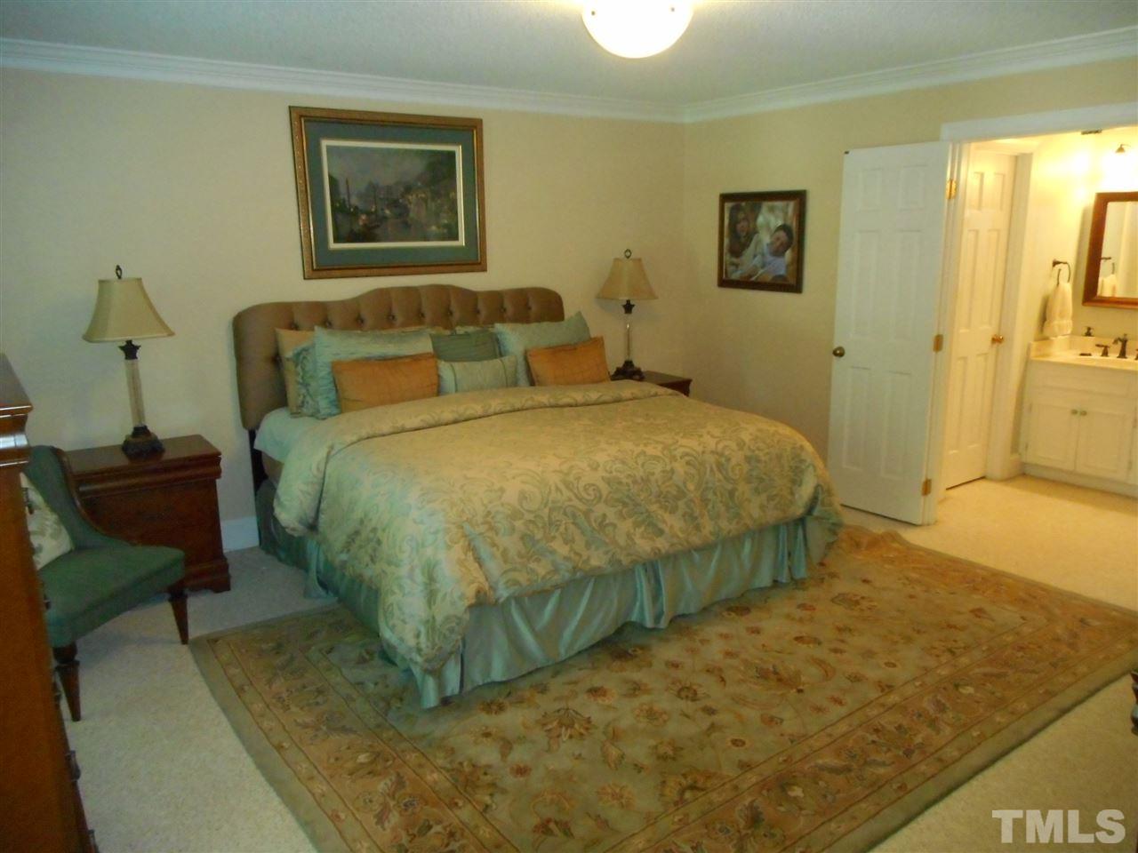 7920 Sutterton Court Raleigh, NC 27615 - Photo 17 of 22 a bedroom with a bed and wooden floor