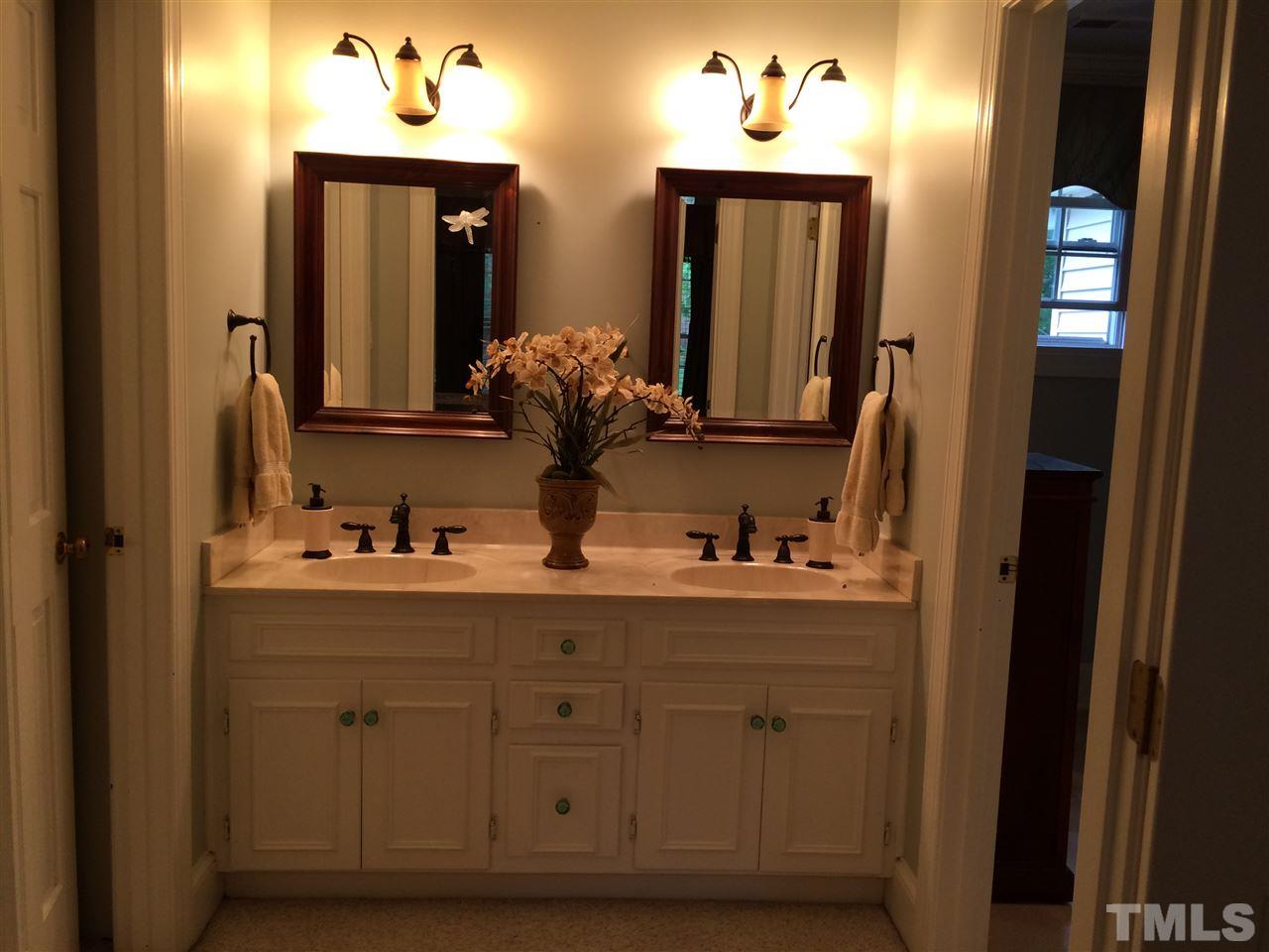 7920 Sutterton Court Raleigh, NC 27615 - Photo 18 of 22 a bathroom with a sink and a mirror