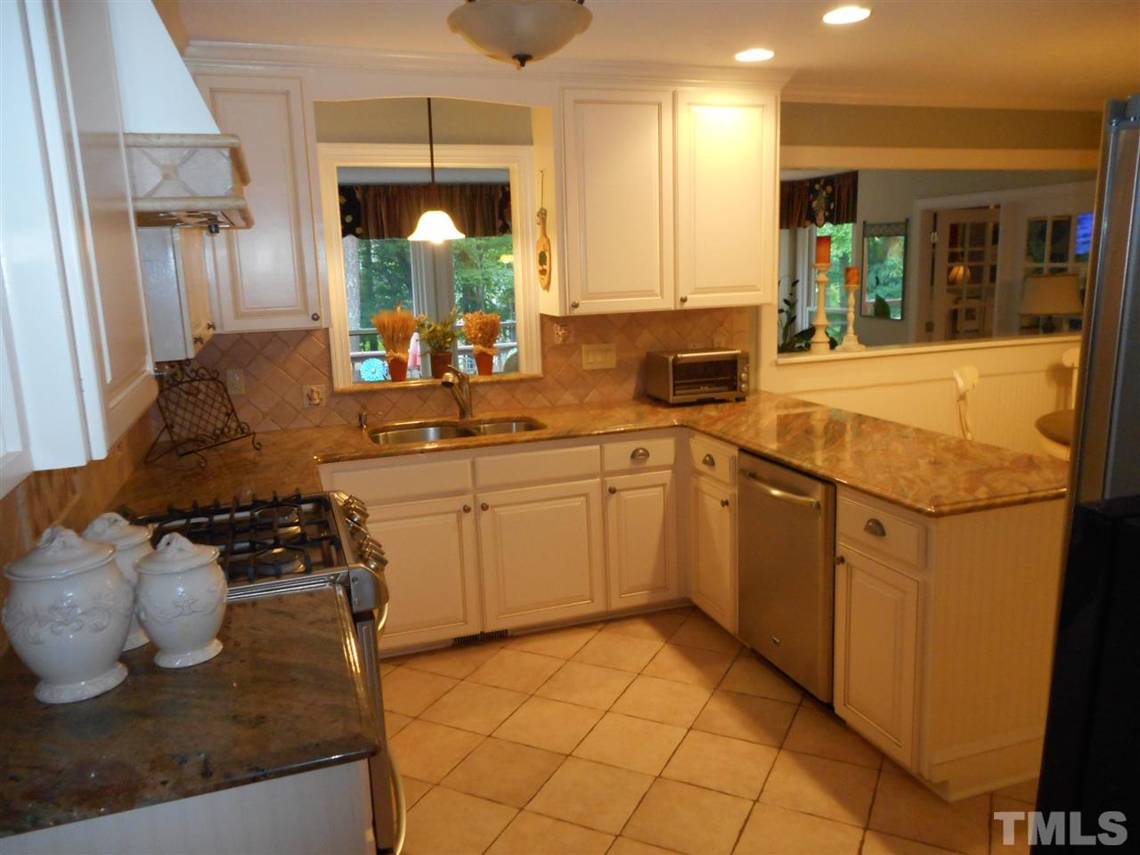 7920 Sutterton Court Raleigh, NC 27615 - Photo 4 of 22 a kitchen with a sink stove and cabinets