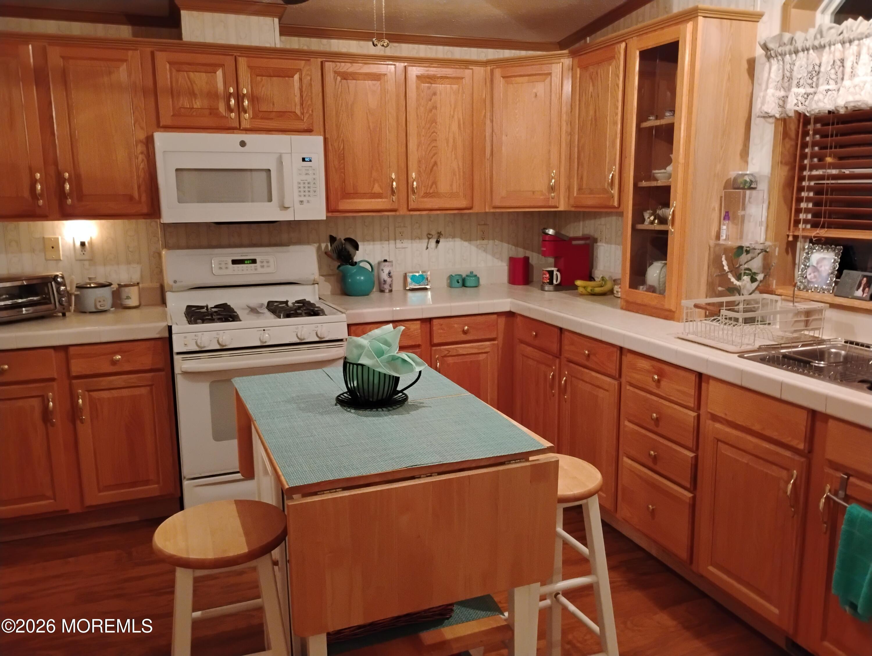 1208 Winding Brook Way Whiting, NJ 08759 - Photo 9 of 21 a kitchen with stainless steel appliances a stove a sink cabinets and a dining table