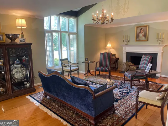 a living room with furniture a fireplace and a chandelier