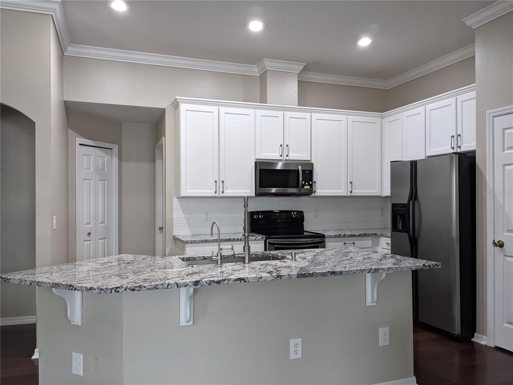 7401 Southwest 86th Way Gainesville, FL 32608 - Photo 4 of 12 a kitchen with stainless steel appliances granite countertop a sink a stove and a refrigerator