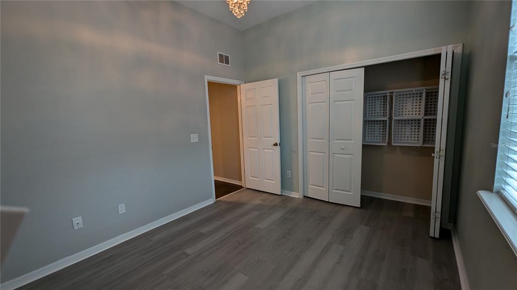 7401 Southwest 86th Way Gainesville, FL 32608 - Photo 9 of 12 an empty room with wooden floor & closet and windows