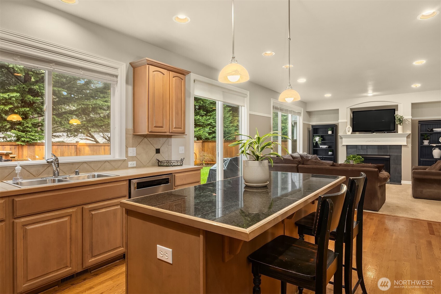 23703 Southeast 284th Street Maple Valley, WA 98038 - Photo 12 of 33 a kitchen with a sink a center island a stove and a window