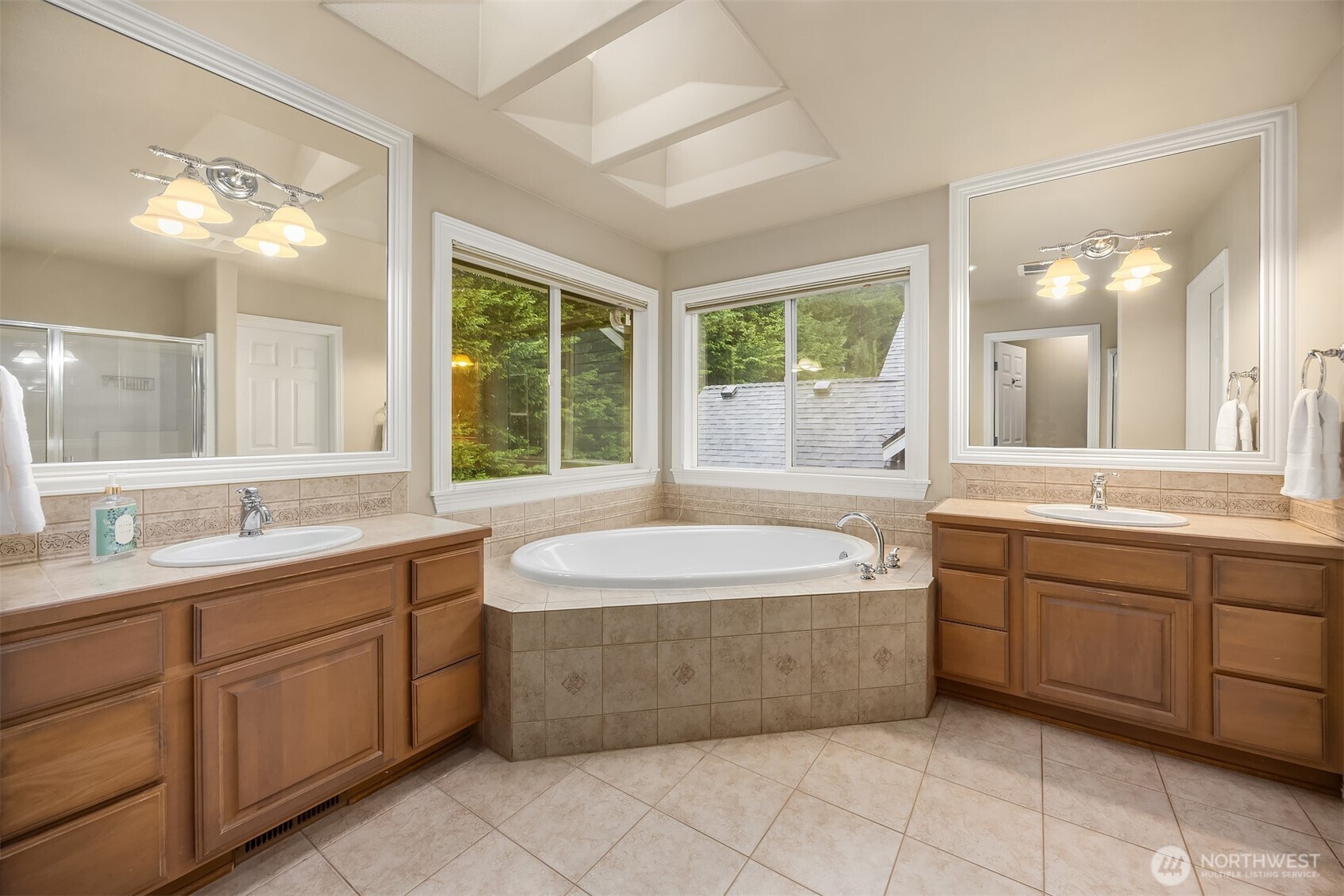 23703 Southeast 284th Street Maple Valley, WA 98038 - Photo 16 of 33 a spacious bathroom with a double vanity sink a large mirror and a bathtub