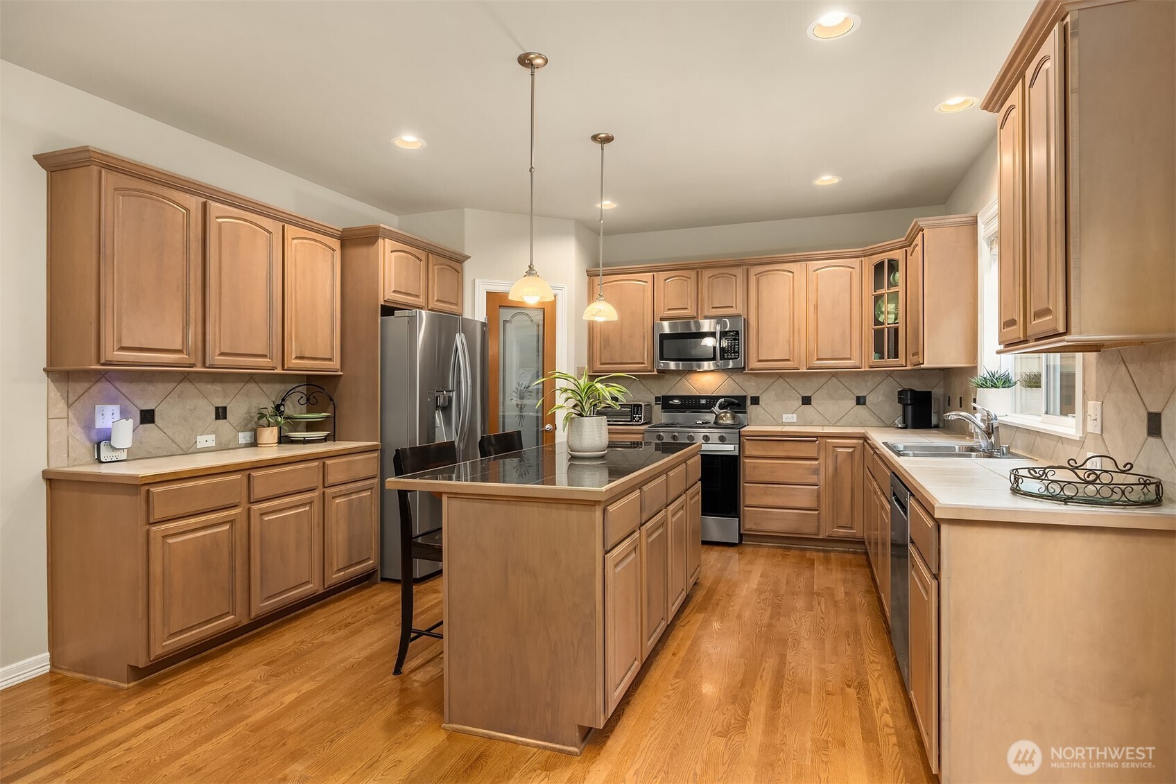23703 Southeast 284th Street Maple Valley, WA 98038 - Photo 8 of 33 a kitchen with kitchen island granite countertop a sink appliances cabinets and furniture