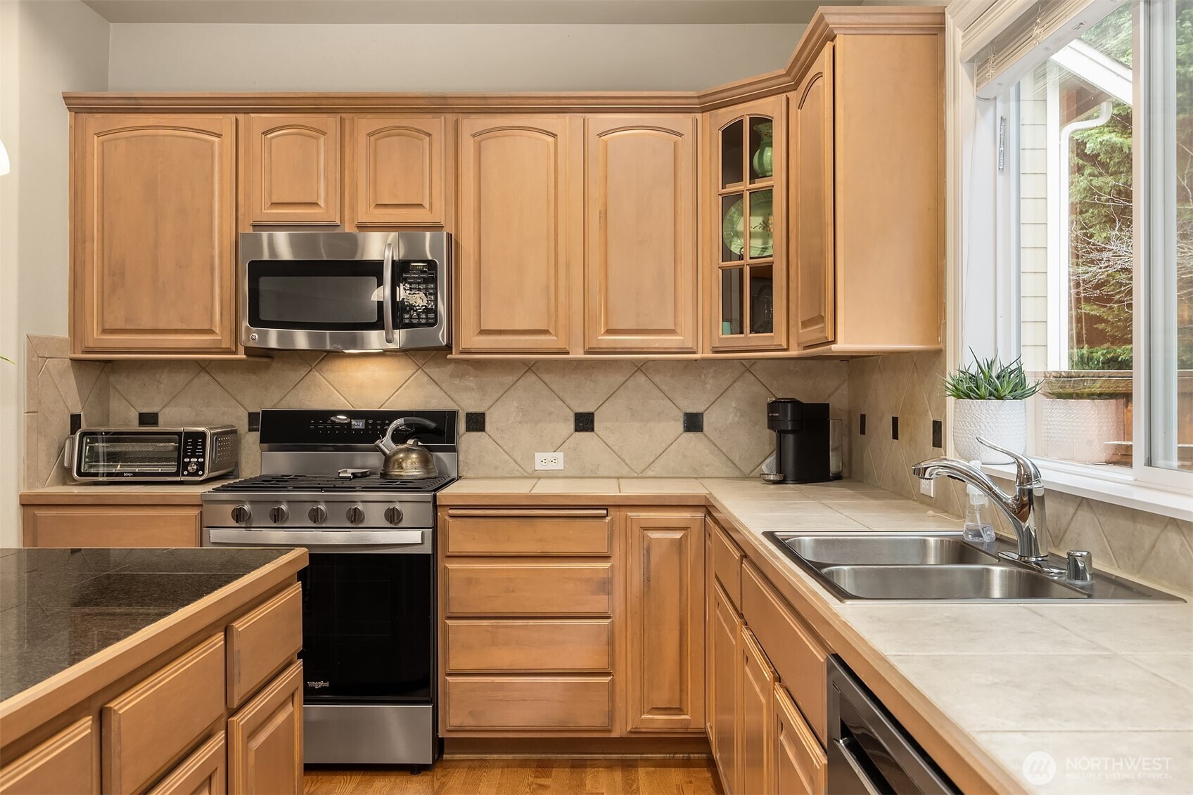 23703 Southeast 284th Street Maple Valley, WA 98038 - Photo 10 of 33 a kitchen with stainless steel appliances granite countertop a stove a sink and a microwave