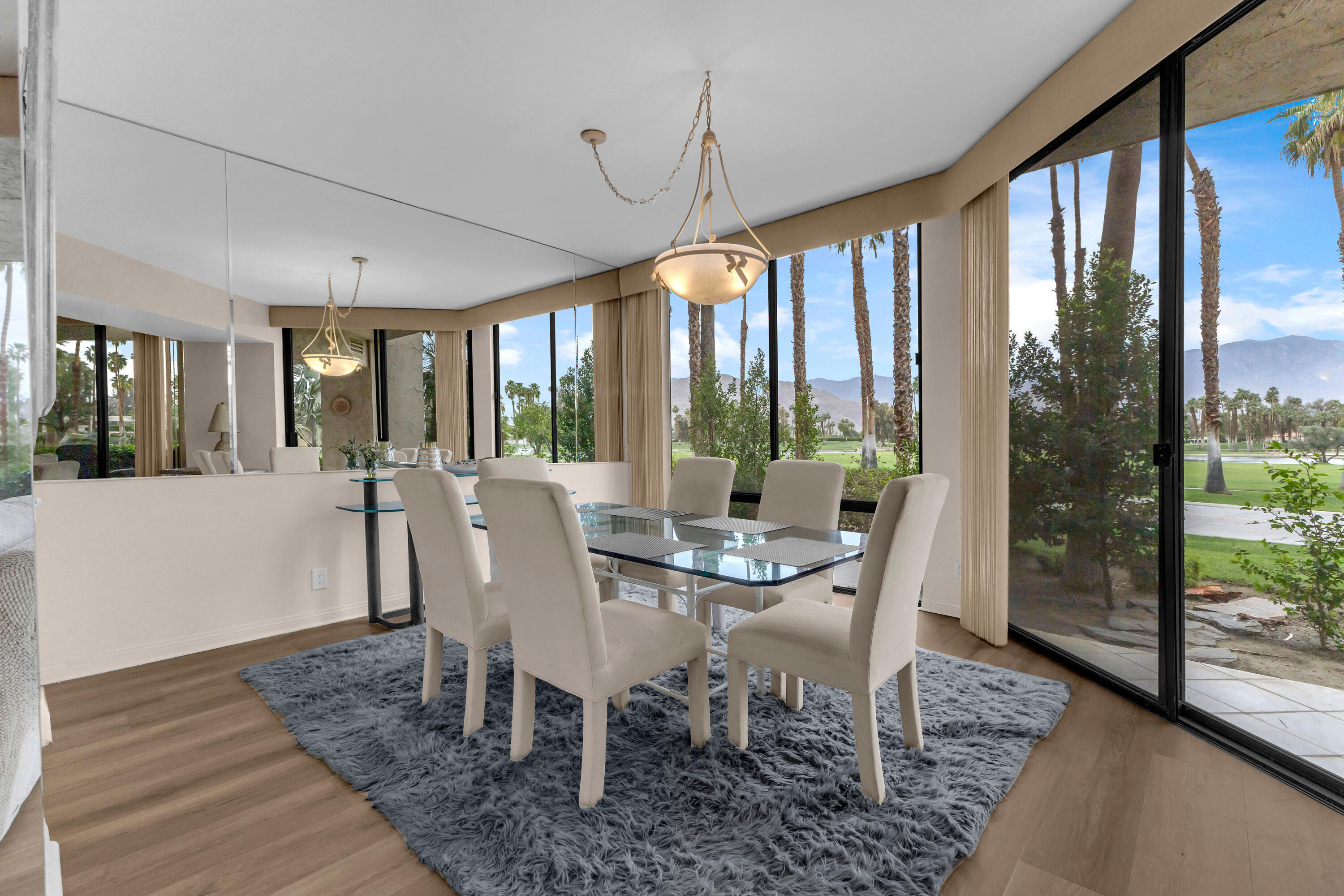 910 Island Drive, Unit 112 Rancho Mirage, CA 92270 - Photo 9 of 47 a view of a dining room with furniture large windows and wooden floor