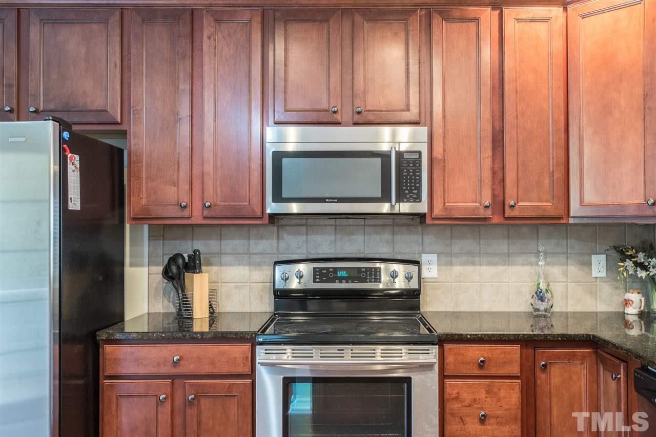 5004 Celtic Court Raleigh, NC 27612 - Photo 11 of 26 a kitchen with granite countertop wood cabinets and stainless steel appliances