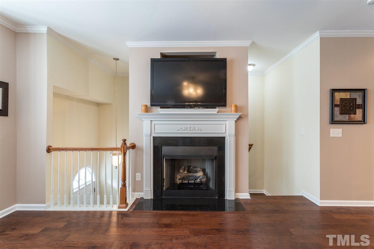 5004 Celtic Court Raleigh, NC 27612 - Photo 6 of 26 a living room with a fireplace and a flat screen tv