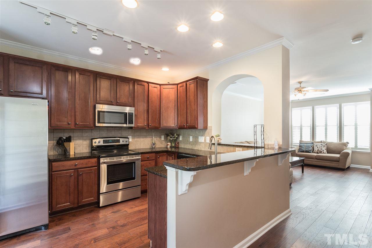 5004 Celtic Court Raleigh, NC 27612 - Photo 8 of 26 a kitchen with stainless steel appliances granite countertop a sink dishwasher stove and refrigerator with wooden floor