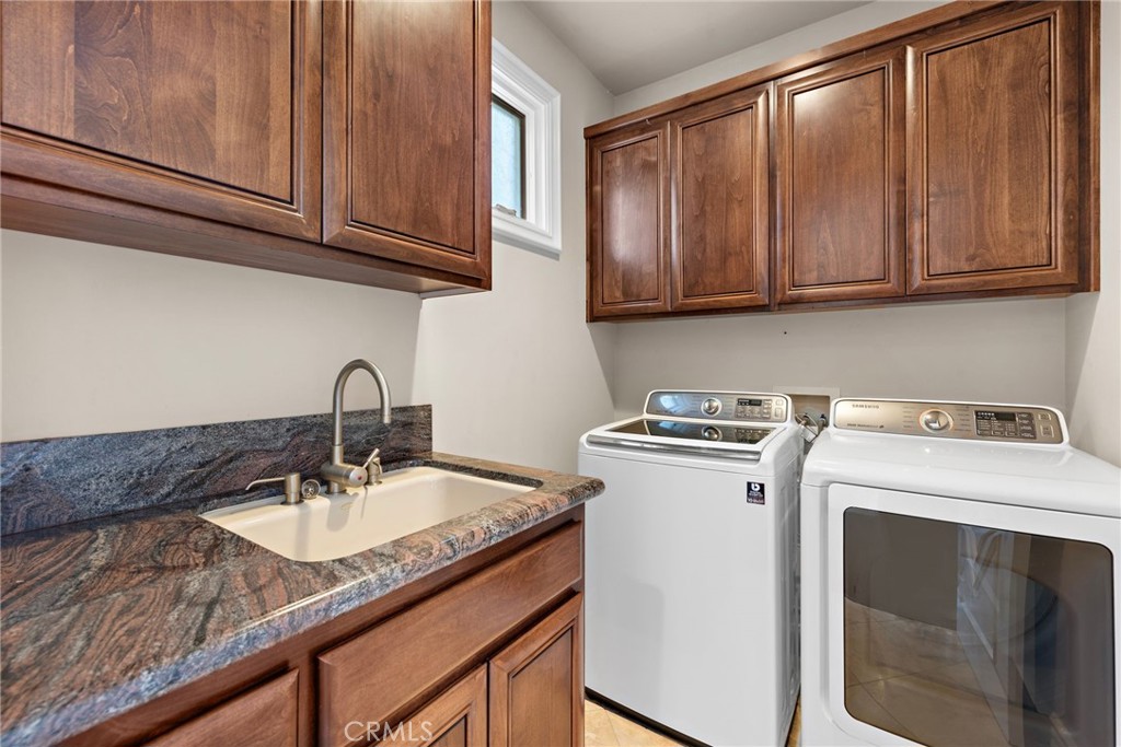 14 Mar Del Rey San Clemente, CA 92673 - Photo 59 of 70 a utility room with granite countertop a sink a stove and cabinets