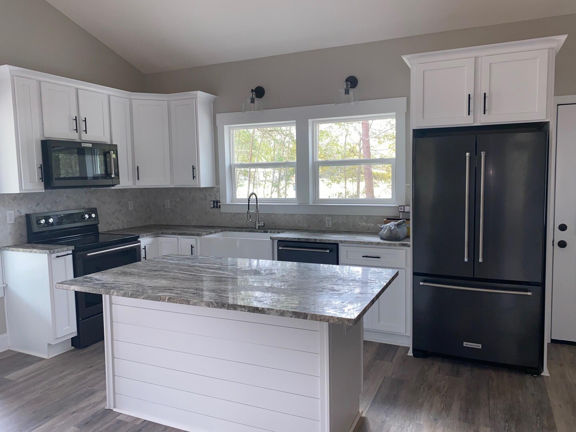 575 East Roberts Road DeFuniak Springs, FL 32433 - Photo 3 of 7 a kitchen with granite countertop a refrigerator and a sink