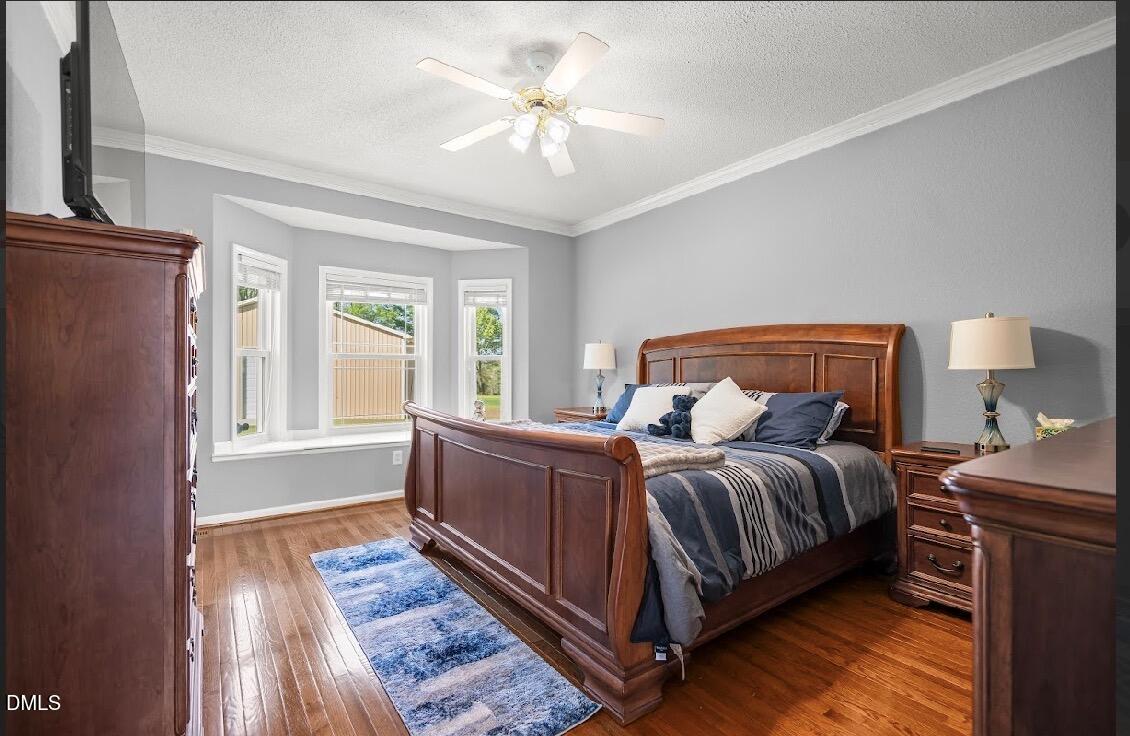 5780 McArthur Road Broadway, NC 27505 - Photo 20 of 40 a bedroom with a bed lamp and a large window with wooden floor