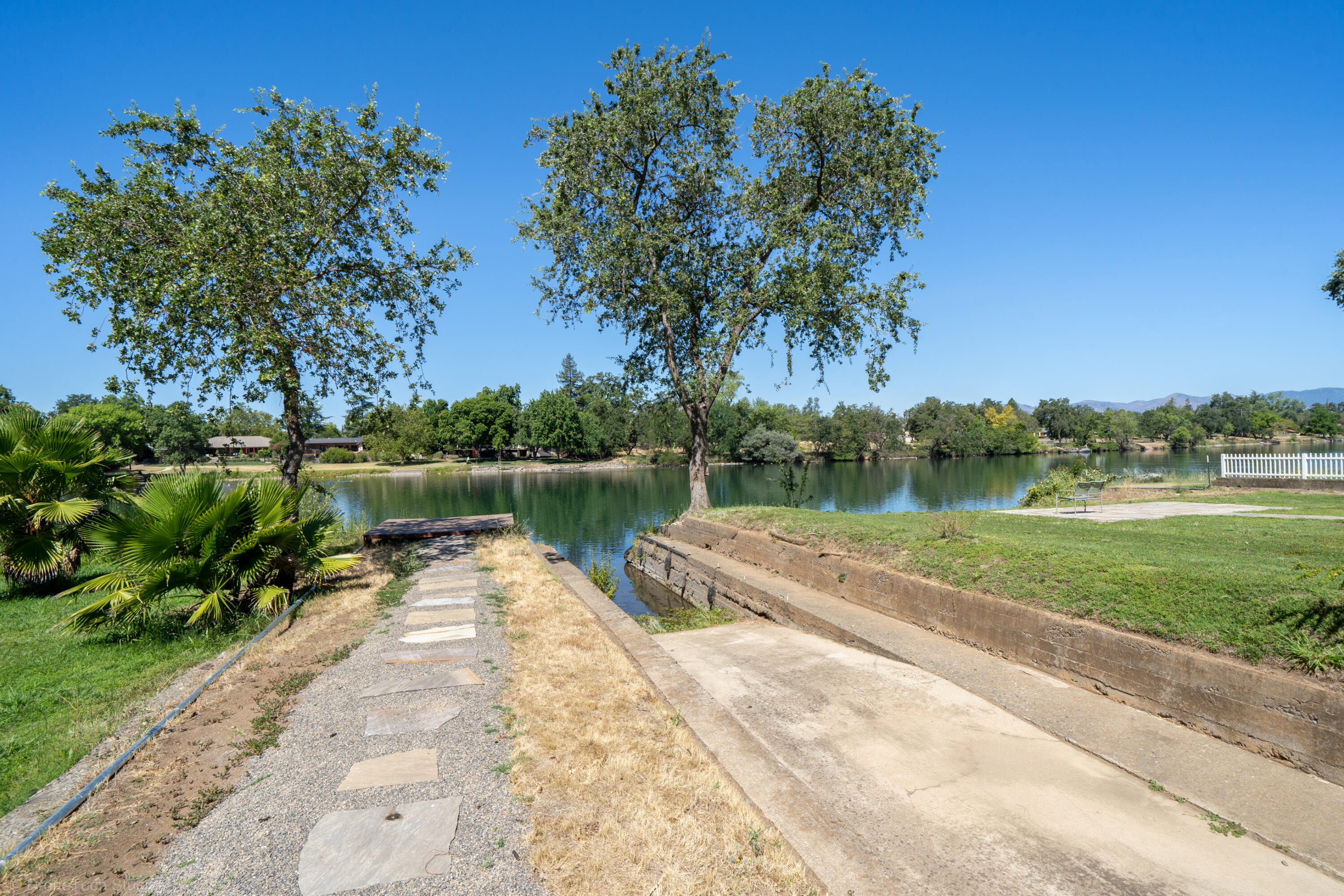 3274 Wilshire Drive Redding, CA 96002 - Photo 74 of 107 a view of a lake with a yard and large trees