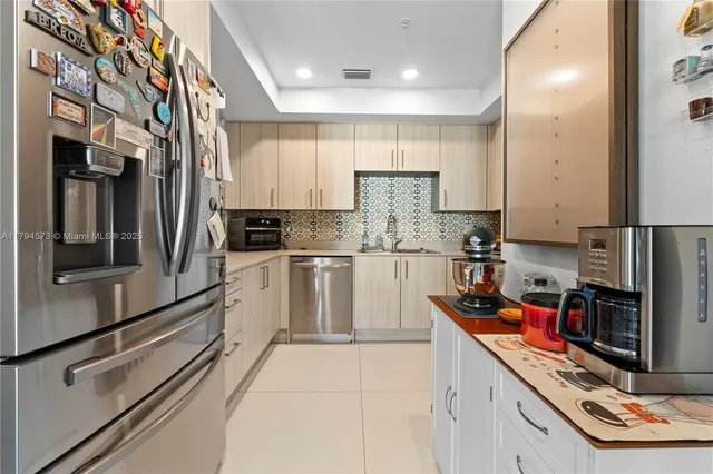 a kitchen with granite countertop white cabinets stainless steel appliances and a sink