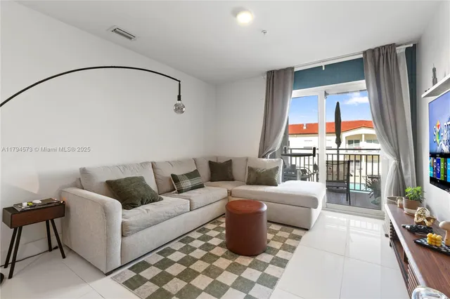 a living room with furniture a rug and white walls