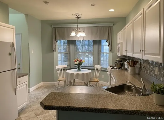 a kitchen with kitchen island granite countertop a sink stainless steel appliances and cabinets