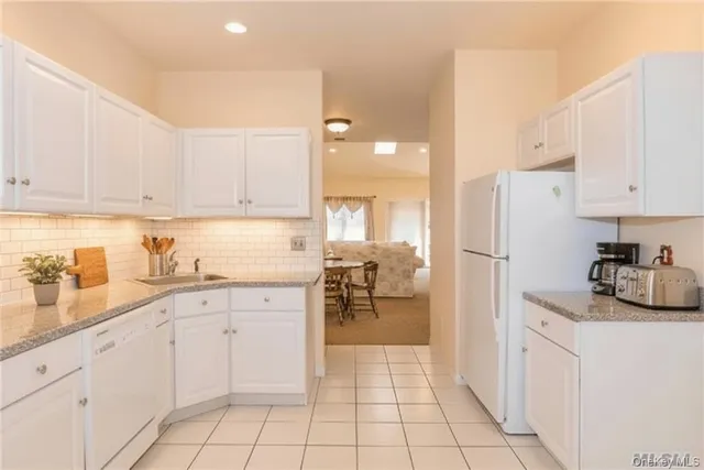 a kitchen with white cabinets and white appliances