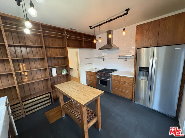 a kitchen with stainless steel appliances a refrigerator and wooden cabinets