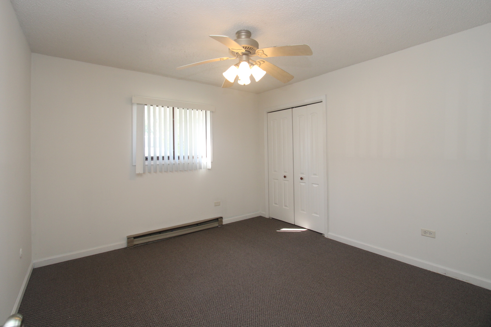 212 Madison Street, Unit 1B Joliet, IL 60435 - Photo 14 of 21 an empty room with windows and chandelier fan
