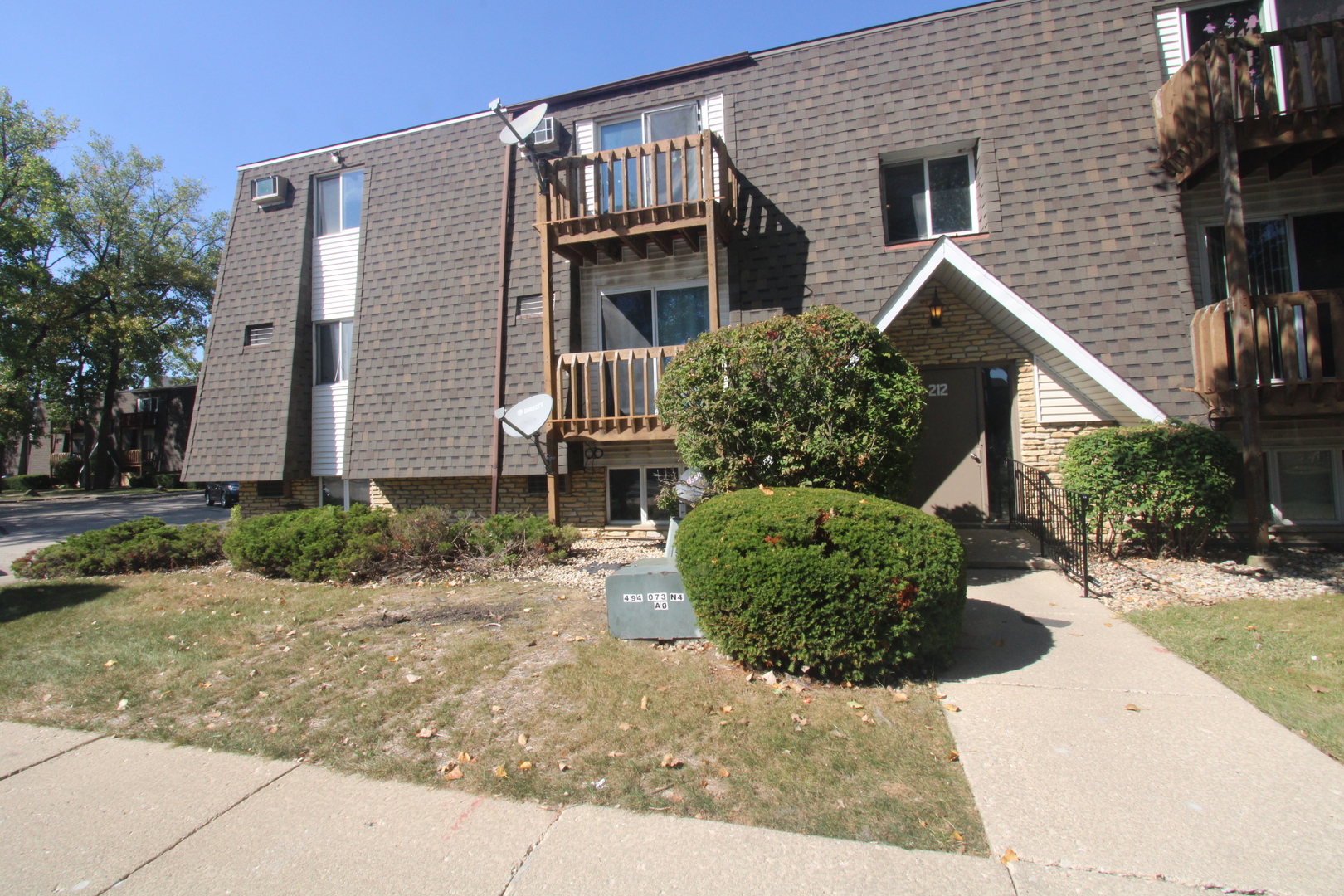 212 Madison Street, Unit 1B Joliet, IL 60435 - Photo 2 of 21 a front view of a house with a yard and potted plants