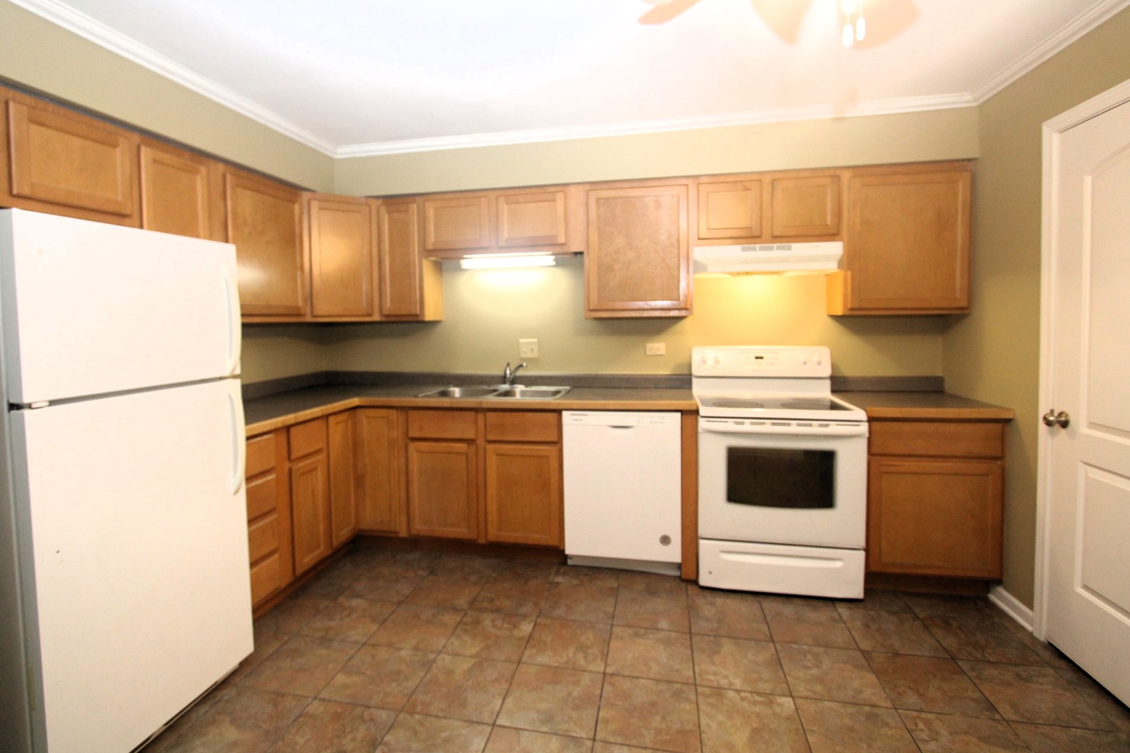 212 Madison Street, Unit 1B Joliet, IL 60435 - Photo 10 of 21 a kitchen with a white stove refrigerator and cabinets
