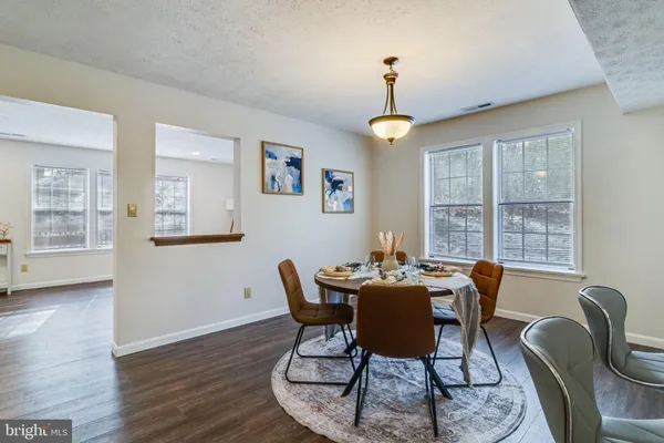 a dining room with furniture a chandelier and wooden floor