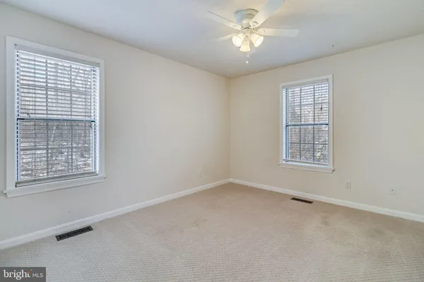 a view of an empty room and chandelier fan
